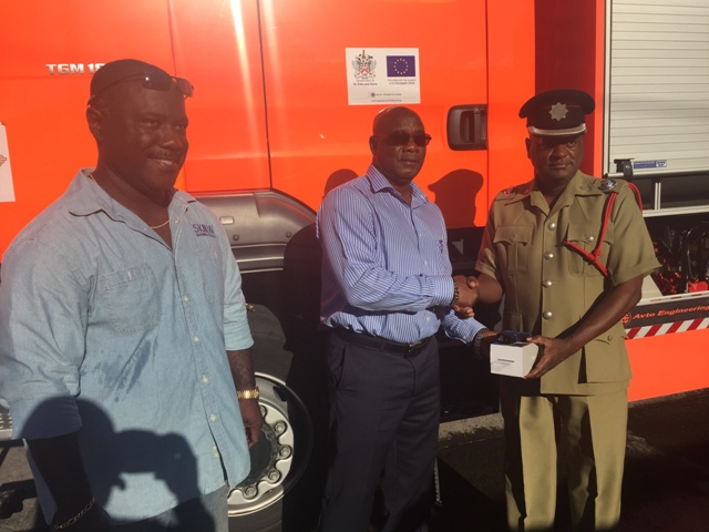 (L-R) Director of St. Kitts Marine Works Ltd. Regiwell Francis looks on as Minister in the Nevis Island Administration Hon. Alexis Jeffers hands over a thermal imaging camera to Divisional Fire Officer David Stapleton in the St. Kitts and Nevis Fire and Rescue Services, Nevis Division at their Headquarters in Charlestown on January 19, 2016